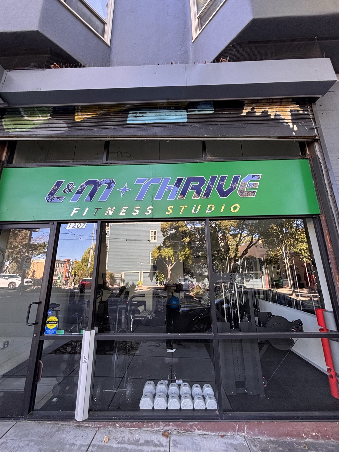 L&M Thrive Fitness Studio storefront and green sign at 1207 Divisadero Street